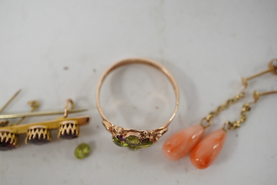 A 9ct gold, peridot and ruby cluster set ring (peridot loose), size P, together with an early 20th century 9ct gold and garnet set bar brooch and a pair of yellow metal and coral set drop earrings, gross weight 5,9 grams